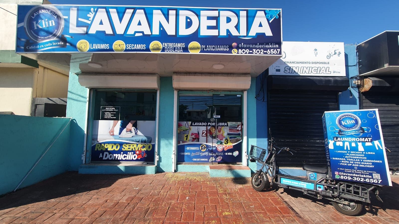 Fachada de Lavanderia Klin en la Calle Olof Palme, Los Prados, con el letrero azul y la moto de delivery